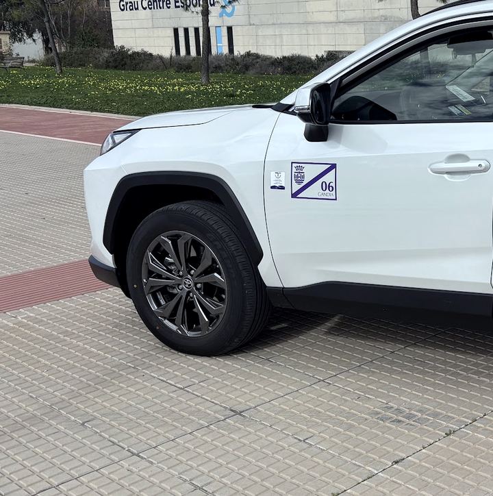 Parte delantera del Toyota RAV4 blanco del Taxi 06, con el escudo de Gandia y el número 06 en la puerta