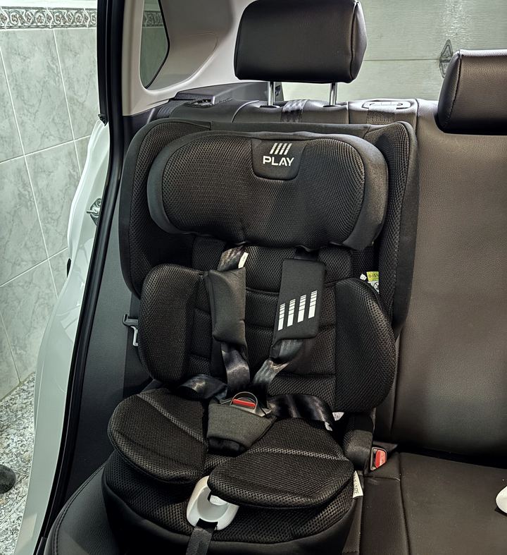 Silla infantil con arnés montada en el asiento trasero, vista de frente